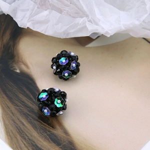 Detailed close-up of spherical beaded earrings with iridescent floral sequins and accents