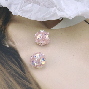 Detail of pink floral beaded ball earrings with iridescent sequins and delicate charm