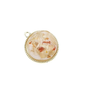 Golden round resin pendant with orange dried flowers and twisted metal frame for DIY jewelry