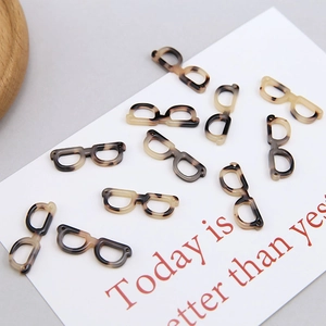 Detailed view of acetic acid eyewear charms with retro tortoiseshell texture for DIY jewelry
