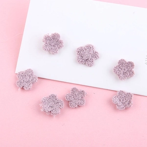 Detailopname van zeven handgebreide paarse wollen bloemen voor DIY-sieraden