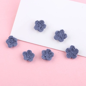 Detail van zes handgebreide gehaakte bloemen van stofblauw katoenen garen voor DIY