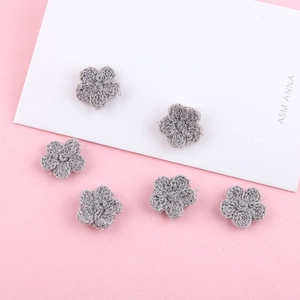 Detail van zes handgebreide grijze bloemen voor DIY-haaraccessoires en sieraden