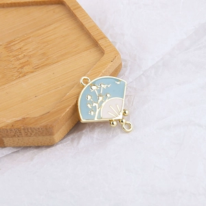 Détail macro d'un pendentif en émail en forme d'éventail de style chinois traditionnel