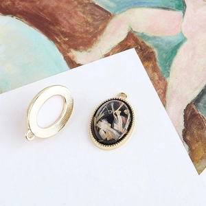 Macro view of vintage oval pendants with gold textured edges and black resin inlay