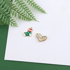 Detail view of festive red and green enamel Christmas stocking charm with gold backing