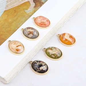 Handmade oval resin pendants with gold metal edges and botanical inlays in various colors