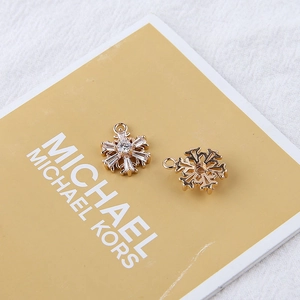 Macro view of 18K gold plated snowflake charms with zircons showing front and back detail