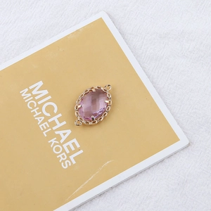 Macro shot of purple faceted stone connector with gold floral frame for DIY jewelry making