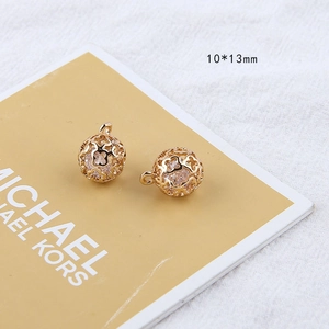 Detailed view of 10x13mm hollow golden sphere pendants with inner white beads