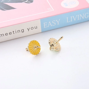 Detail view of yellow enamel umbrella charms with gold alloy finish and earring hooks