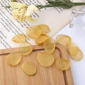 Close-up of golden mesh floral petals on vintage book page for DIY jewelry making