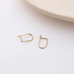 Detailed close-up of 18K gold plated minimalist D-shaped geometric stud earrings