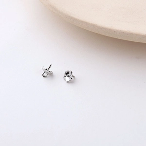 Macro detail of silver flower petal earring studs with hanging loops for DIY jewelry