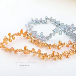 Macro shot of iridescent water-drop glass beads with golden and aurora blue mermaid finish