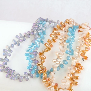 Macro detail of iridescent teardrop glass beads in various colors for DIY jewelry