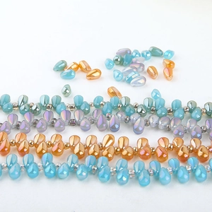 Detailed macro of iridescent teardrop beads in sky blue and amber for DIY jewelry