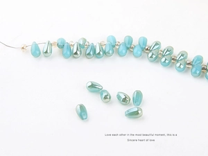Macro shot of iridescent water-drop glass beads with a soft aurora pearl coating