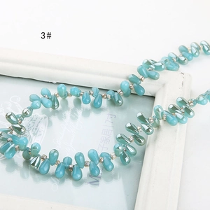 Macro shot of iridescent teardrop beads in cyan blue for DIY handmade jewelry crafts