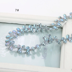 Macro shot of iridescent light blue teardrop beads on a vintage frame for DIY jewelry