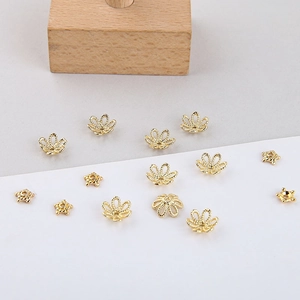 Detailed macro view of 18k gold plated filigree flower bead caps and star spacer beads