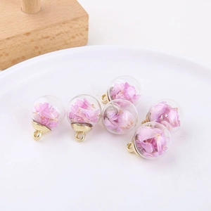 Close-up of 6 glass globe charms with purple dried flowers and gold metal loops