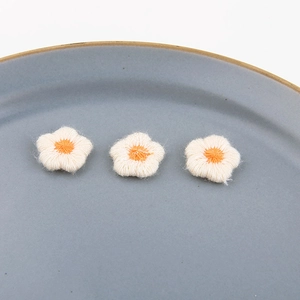 Drie handgemaakte crème gehaakte bloemen met oranje meeldraden voor doe-het-zelf sieraden
