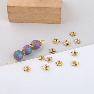 Close-up of gold star flower bead caps on purple frosted beads for DIY jewelry making