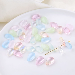 Close-up of colorful mermaid tear glass drop beads for DIY jewelry making in a white dish