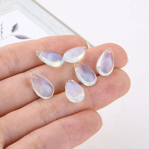 Macro shot of six translucent teardrop glass pendants with iridescent blue glow for DIY
