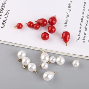 Detail of red and white faux pearl drops with gold rings for DIY jewelry making