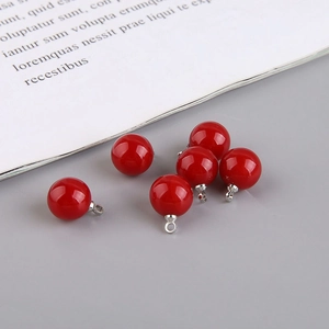 Detail of six glossy red spherical pendant beads with silver metal clasps for DIY jewelry