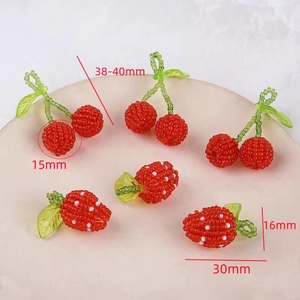 Macro detail of handmade beaded cherry and strawberry pendants with size dimensions