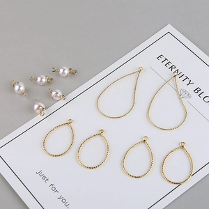 Makroaufnahme von 18K vergoldeten Tropfenrahmen und Perlenanhängern für DIY-Schmuck