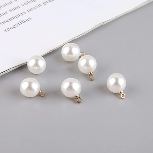 Macro detail of white imitation pearls with golden alloy rings for DIY jewelry making