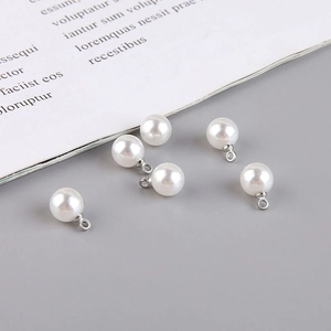Detailed view of six white faux pearl teardrop pendants with silver bails for DIY jewelry