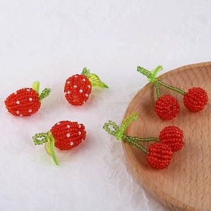 Handmade beaded charms showing detailed strawberry and cherry fruit shapes for jewelry DIY