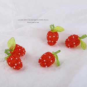 Handmade red beaded strawberry charms with green leaf accents for DIY jewelry making