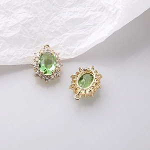 Dettaglio macro del ciondolo ovale in zircone verde con base dorata e zirconi bianchi