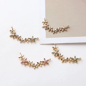 Detailed macro of gold-plated flower cluster charms with inlaid colorful zircons for DIY
