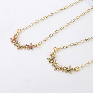 Macro detail of gold-plated paperclip chain necklaces with colorful zircon flower clusters