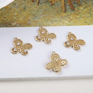 Details von vier goldenen Filigran-Schmetterlingsanhängern mit weißen Zirkoniasteinen