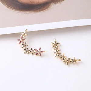 Macro detail of gold-plated flower cluster pendant with red and white cubic zirconia