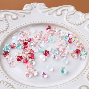 Makroansicht bunter Herzperlen aus Glas für DIY-Schmuck in einer weißen Porzellanschale