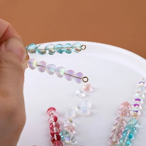 Makroaufnahme von irisierenden Glasperlen in Herzform für DIY-Schmuck und Bastelarbeiten