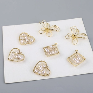 Vista detallada de colgantes de corazón y mariposa en hilo de oro 18K con perlas finas