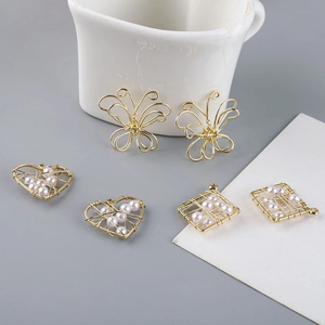 Detalle de colgantes de hilo de oro 18K con perlas en forma de corazón y mariposa