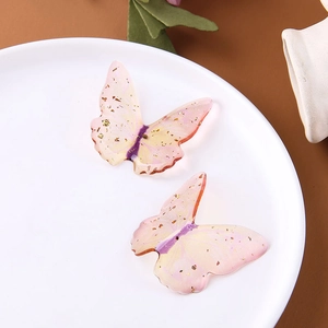 Dettaglio macro di farfalle in resina sfumata con foglie d'oro per accessori fai-da-te