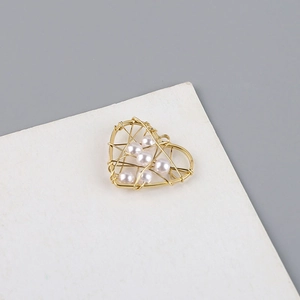 Detalle del colgante de corazón bañado en oro de 18K con perlas y alambre trenzado