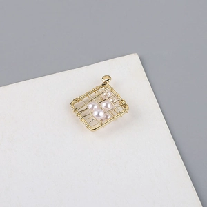 Vista macro del colgante cuadrado chapado en oro 18K con perlas blancas envueltas en hilo